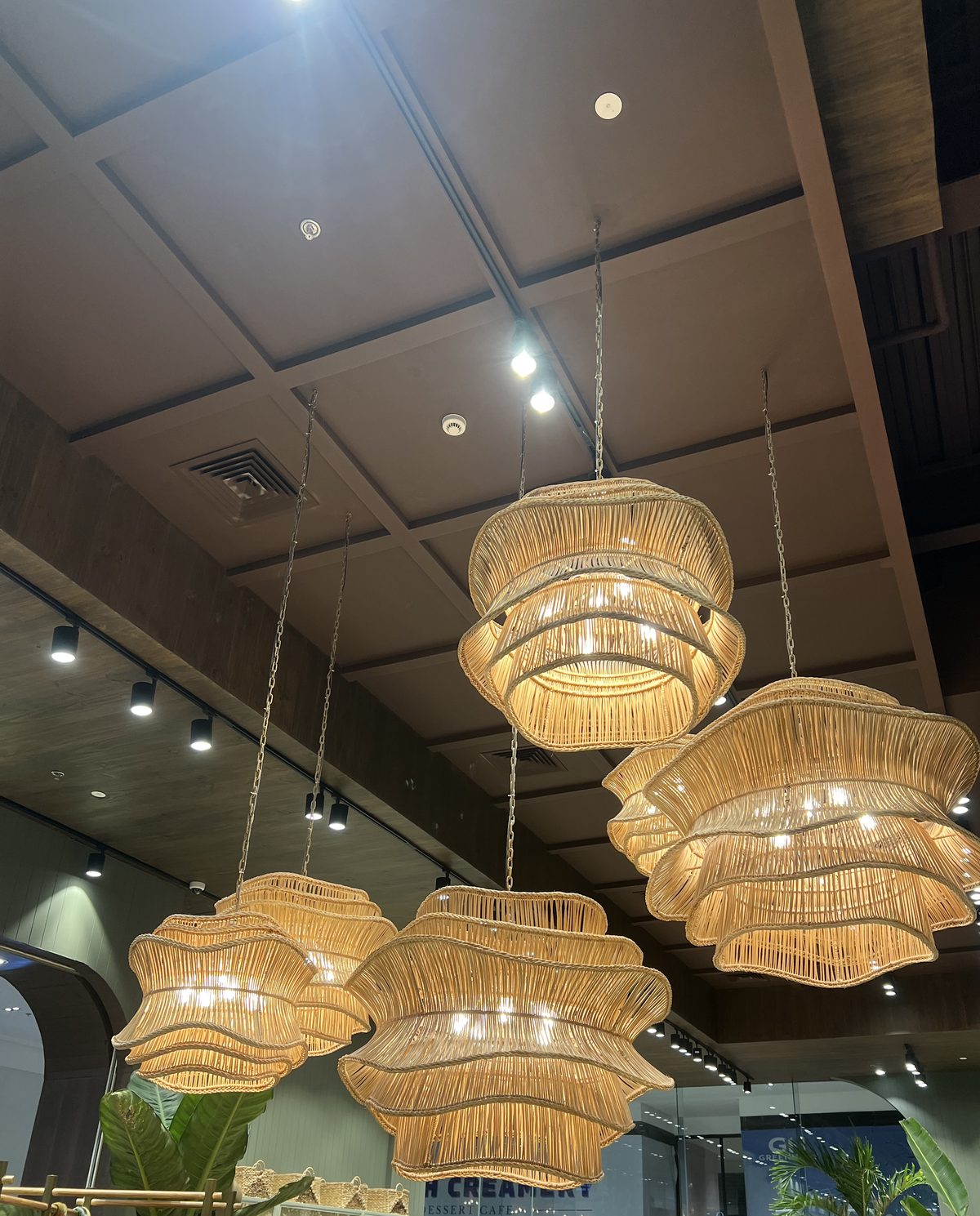 Layered scalloped rattan chandeliers hanging in the double-height ceiling of the Kultura store, Greenhills Mall