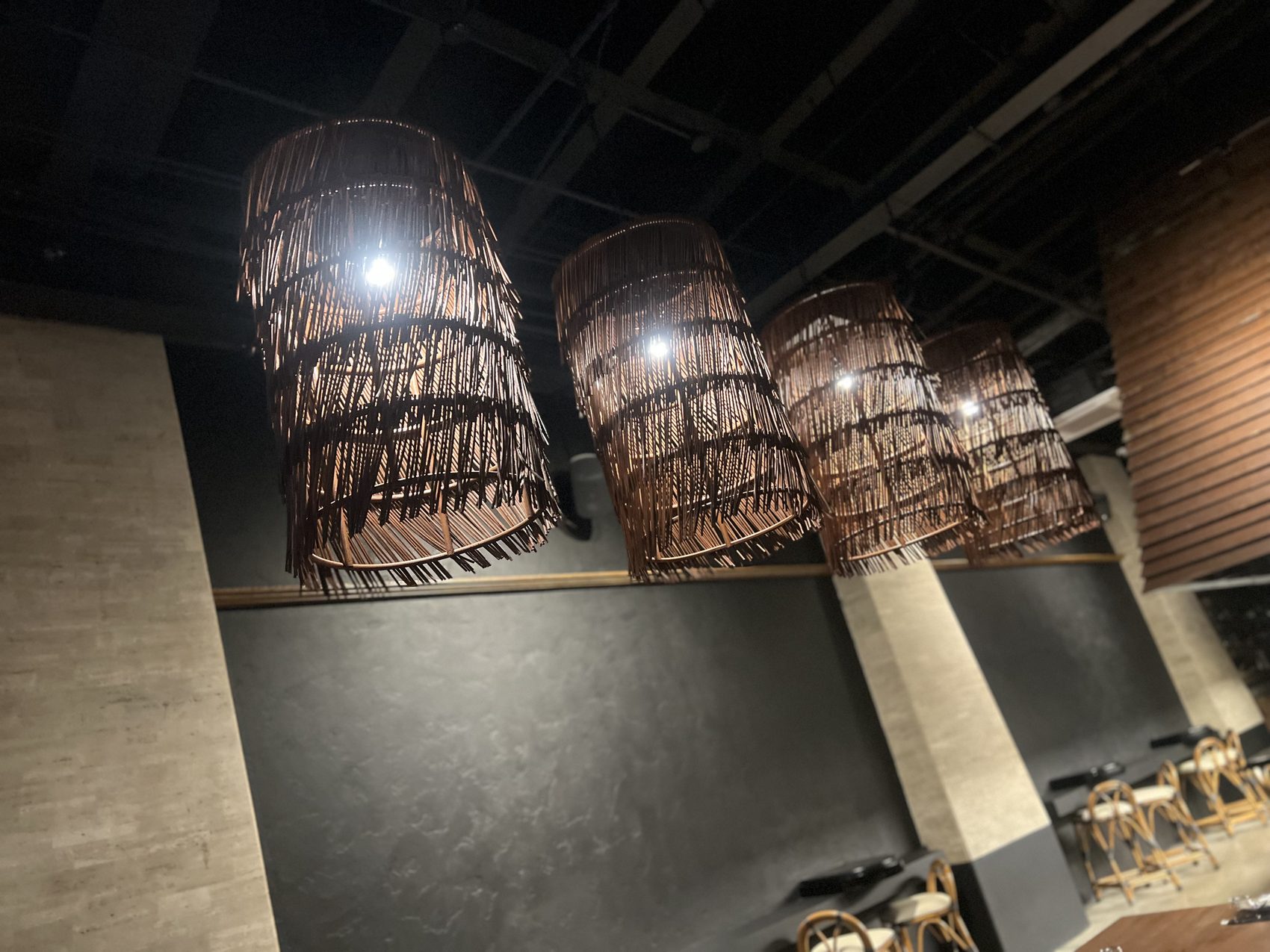 A row of rattan fringe drum pendant lights along the main dining hall at Toma Toma, Makati